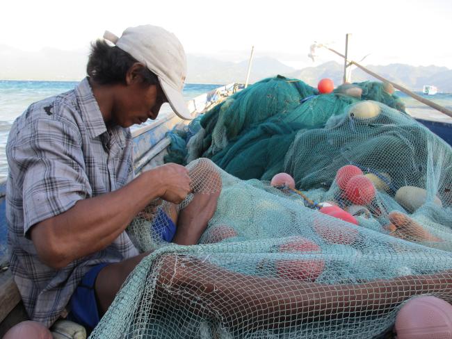 A fisherman is fixing his net at Gili @WCS